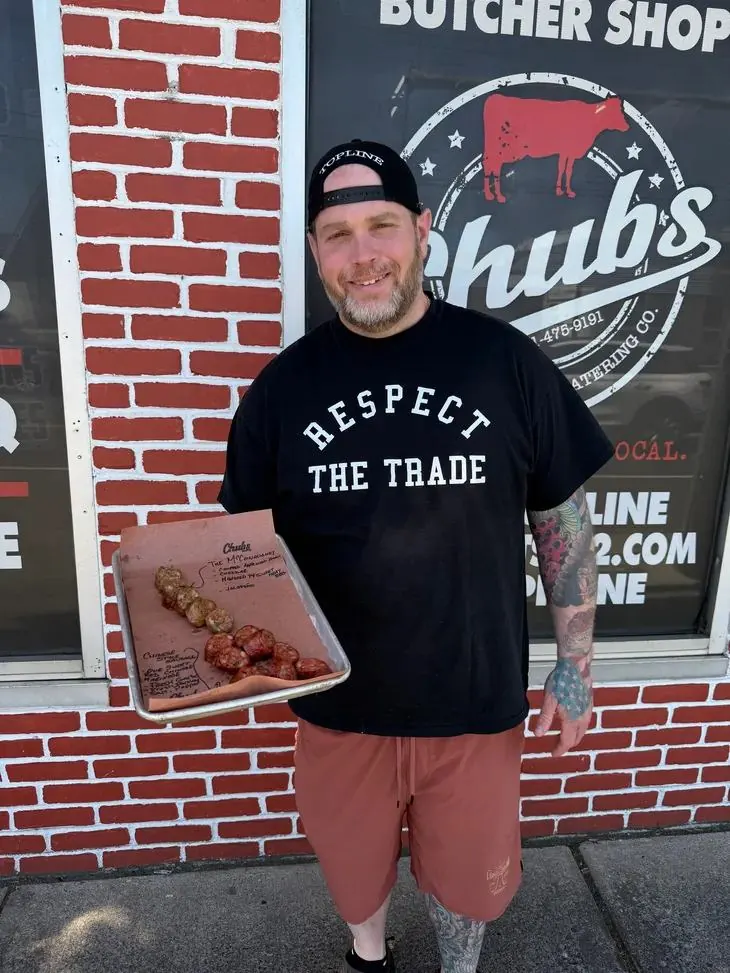 Tom outside the Chubs butcher shop holding a tray of house-made sausage